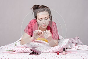 Girl enthusiastically saws, nails lying in bed