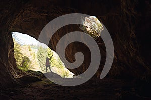 Girl in the entrance of a cave