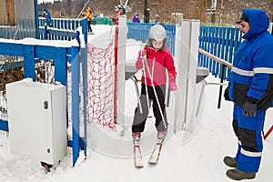 Girl equipped for skiing at turnstile at photo