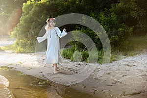 Girl in ethnic clothes with wreath of flowers celebrating