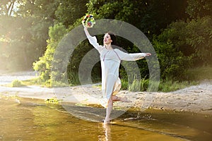 Girl in ethnic clothes with wreath of flowers celebrating