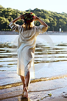 Girl in ethnic clothes with wreath of flowers celebrating