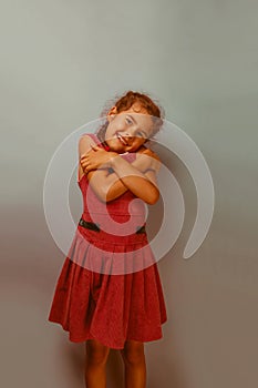 Girl European appearance decade hugging herself on