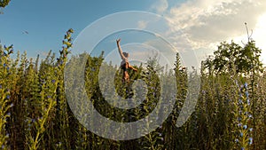 Girl exalts waves with hands smiles among wild blue flowers multitude of butterflies fly blue sky sunny day ukrainian steppe