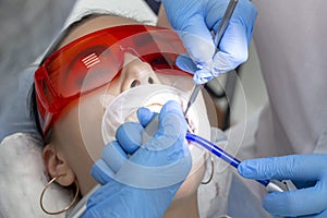 Girl on examination at dentist. treatment of carious tooth. the doctor uses a mirror on the handle and a boron machine