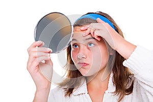 Girl examine her pimples in the mirror