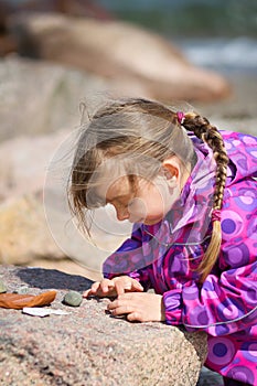 Girl Examining Beach Pebble