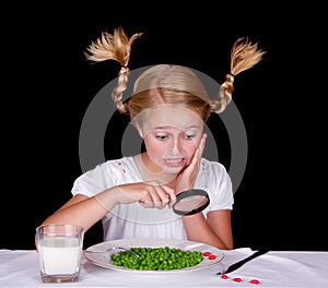 Girl examining bugs on table with magnifying glass