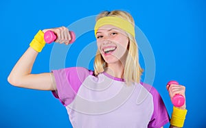 Girl exercising with dumbbell. Fitness instructor hold little dumbbell blue background. How to get toned physique