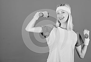 Girl exercising with dumbbell. Fitness instructor hold little dumbbell blue background. How to get toned physique
