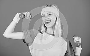 Girl exercising with dumbbell. Fitness instructor hold little dumbbell blue background. How to get toned physique