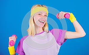 Girl exercising with dumbbell. Fitness instructor hold little dumbbell blue background. How to get toned physique