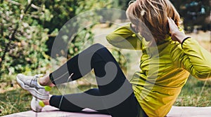 Girl exercising outdoors. Young fit woman doing stretching exercises  training outside in green park. Sport woman play yoga