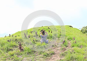 Girl exercising yoga among stone stacks on Padar Island