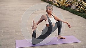 Girl exercising with yoga stretching poses, outside training