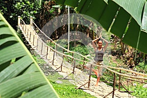Girl exercising yoga on traditional bridge over river photo