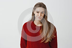 Girl expresses disdain to rival. Portrait of displeased unimpressed beautiful woman in fashionable red loose sweater photo