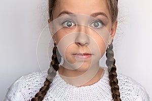 Girl expresses fright, close-up in white clothes on a white background