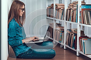 Girl in Eyeglasses Does Research on Laptop.