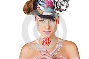 Girl with face-art holding lollipop