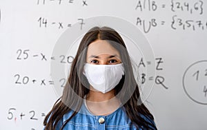 Girl with face mask back at school after covid-19 quarantine and lockdown.