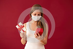 Girl with face mask opening present on valentines day