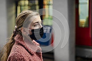 Girl with face mask waiting for metro