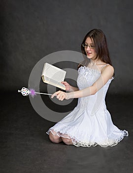 Girl - fairy with magic wand and book in hands