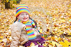 Girl on fall autumn leaves in park