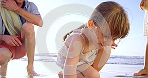 Girl, family or drawing in sand, beach or game for trip or playing on vacation in nature in summer. Happy child, parents