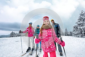 Girl with family on ski slope on vacation in mountain