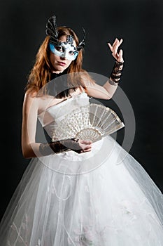 Girl with fan and mask in white dress