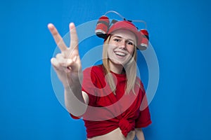 Girl fan shows fingers number two on a blue background and smiles, cheerleader in uniform