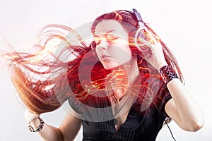 Girl fan sings and dances listening to music. Young brunette woman in big headphones enjoys music