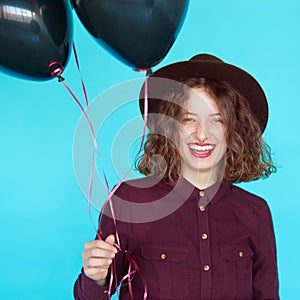 Girl in fashion clothes holding colored black balloons