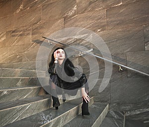 Girl in fashionable black casual clothes on background of stone wall, modern urban architecture, vogue style photo