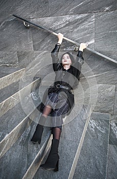 Girl in fashionable black casual clothes on background of stone wall, modern urban architecture, vogue style photo