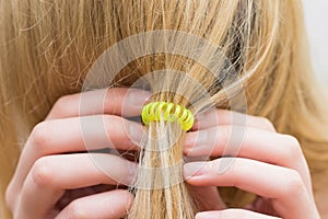 The girl fastens hair an elastic band