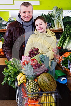 Girl with father choosing pineapple