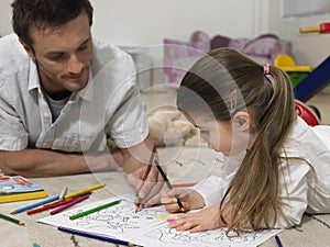 Girl And Father Coloring Book Together On Floor