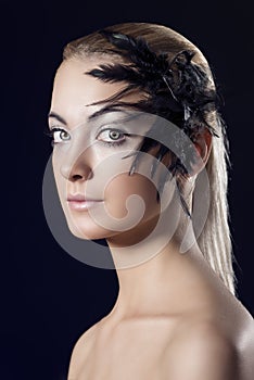 Girl with feathered accessory, she looks in to the lens