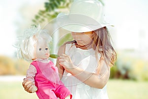 Girl feeding her doll outdoors