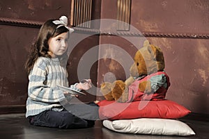 Girl feeding a teddy bear