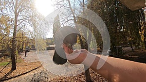 Girl feeds a pigeon that sits on her hand on a sunny autumn day