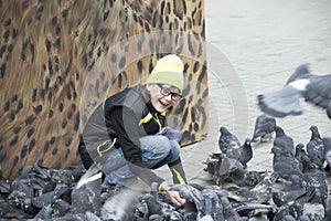 Girl feeds pigeons on the city square