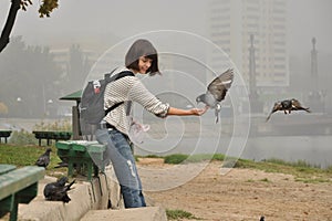 Girl feeds pigeons, smiling