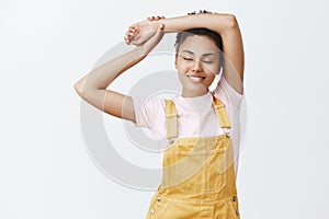 Girl feeling great after meditation. Portrait of calm and relaxed feminine dark-skinned woman in stylish yellow