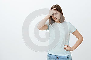 Girl feeling humiliated seeing mom near university. Awkward displeased and embarrassed cute young woman in t-shirt