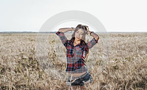 Girl in a field shirt shorts, wheat outdoor recreation, beautiful hair. Corrects hair.
