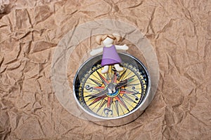 Girl figurine on top of compass as education and business concept